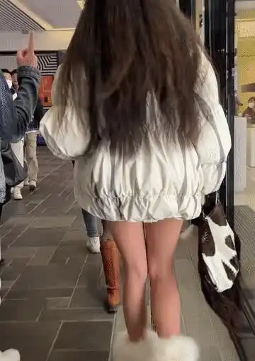 女子上身穿羽绒服,下身光腿穿棉鞋,因衣着奇葩引路人围观
