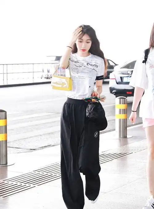 李菲儿现身机场,穿t恤阔腿裤显高又显瘦,边走边撩发风情万种
