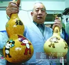 老人将奥运会吉祥物福娃烙在葫芦上
