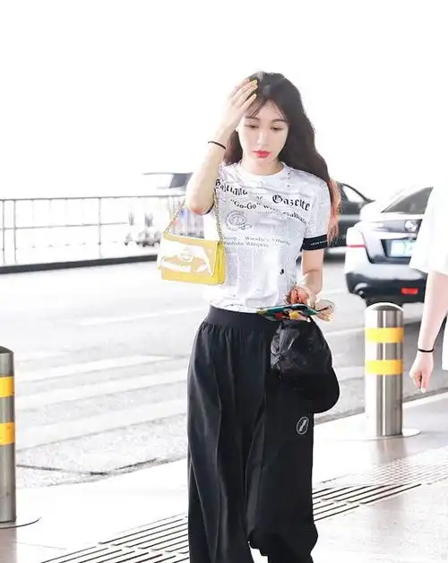 李菲儿现身机场,穿t恤阔腿裤显高又显瘦,边走边撩发风情万种
