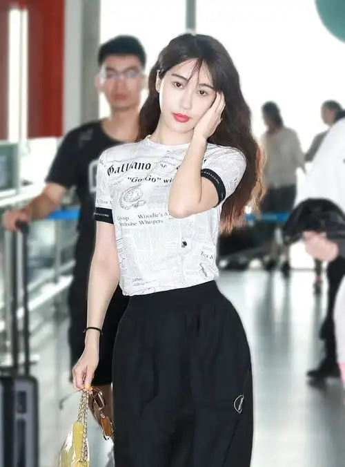 李菲儿现身机场,穿t恤阔腿裤显高又显瘦,边走边撩发风情万种
